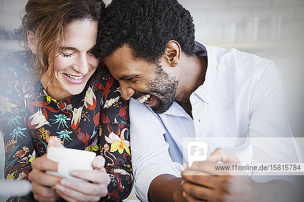 Zärtliches  lächelndes  multiethnisches Paar beim Kaffeetrinken