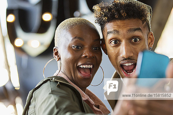 Verspieltes junges Paar macht Selfie mit Fotohandy