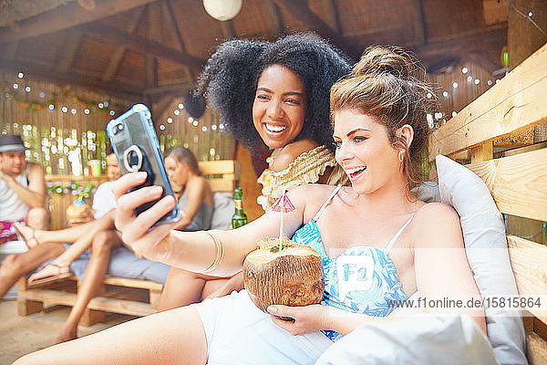 Junge Frauen Freunde mit Kamera-Handy unter Selfie trinken Kokosnuss-Cocktail im Sommer am Pool