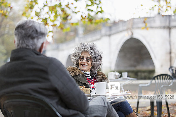Aktives Seniorenpaar im Gespräch und beim Kaffee im Herbstparkcafé