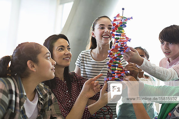 Lehrerin und Schüler untersuchen das DNA-Modell im Klassenzimmer