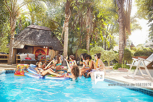 Junge Freunde hängen am tropischen Sommerschwimmbad ab