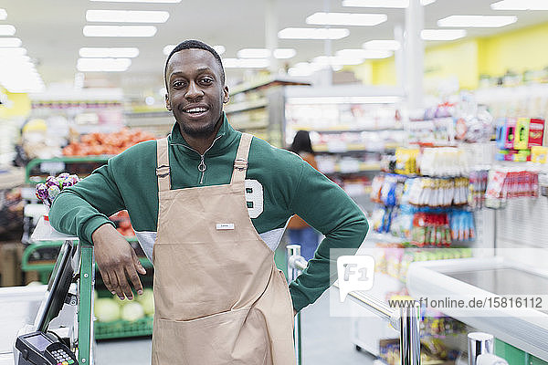 Porträt selbstbewusster männlicher Lebensmittelhändler bei der Arbeit im Supermarkt