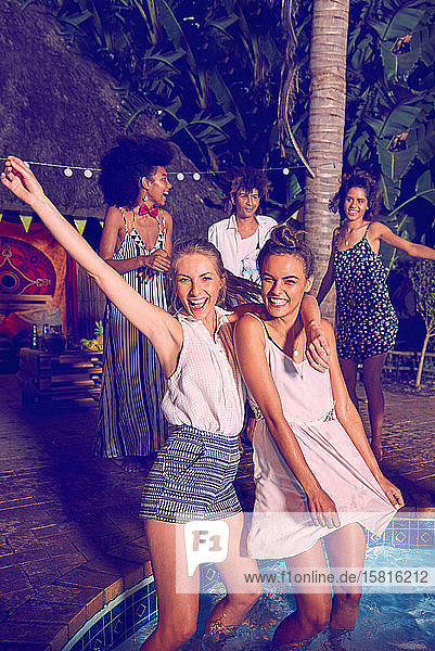 Porträt ausgelassene junge Frauen Freunde feiern  tanzen und waten bei Pool-Party