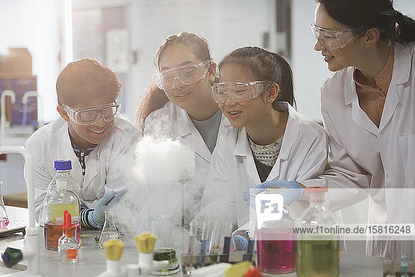 Lehrerin und Schüler beobachten wissenschaftliches Experiment chemische Reaktion im Labor Klassenzimmer