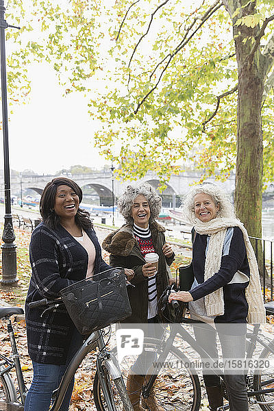 Porträt lächelnd  zuversichtlich  aktive ältere Frauen Freunde mit Kaffee und Fahrräder im Herbst Park