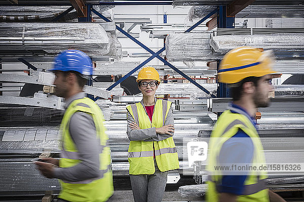 Porträt einer selbstbewussten,  lächelnden Aufseherin in einem Stahlwerk