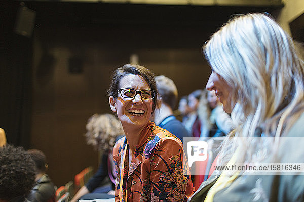 Laughing businesswomen in conference audience