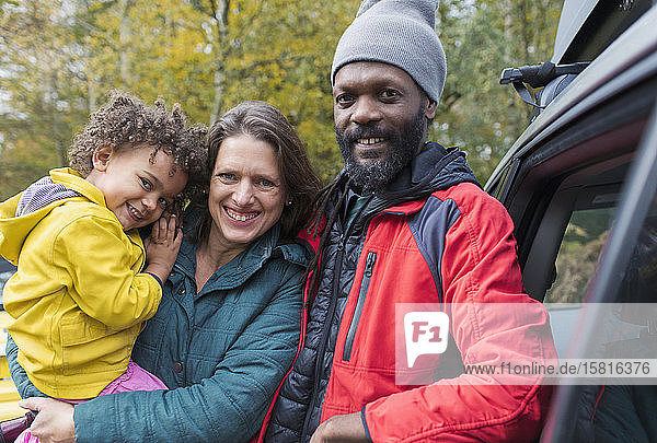 Porträt einer glücklichen multiethnischen Familie  die vor einem Auto steht