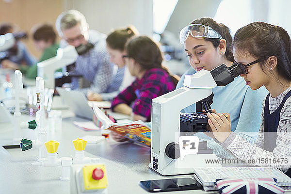 Studentin mit Mikroskop  die ein wissenschaftliches Experiment im Laboratorium durchführt