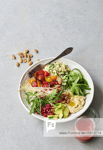 Eine Salatschüssel mit Couscous  Gemüse und einem fruchtigen Dressing