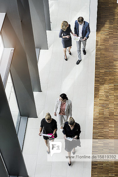 Geschäftsleute gehen in einem modernen Bürogebäude