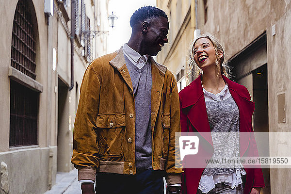 Happy young couple strolling through an alley in the city of Florence  Italy