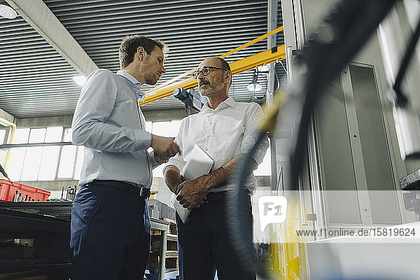 Two men talking in a factory