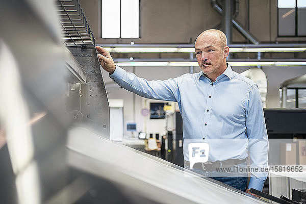 Businessman at a machine in a factory