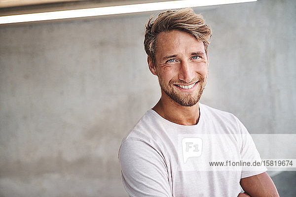 Porträt eines lächelnden jungen Mannes mit weißem T-Shirt