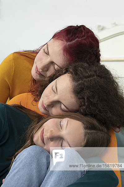 Portrait of three sisters head to head with eyes closed