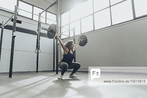 Young woman weightlifting in gym