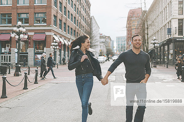 Happy couple walking down a city street  Vancouver  Canada