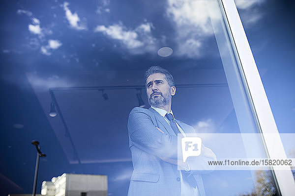 Portrait of a mature businessman behind windowpane