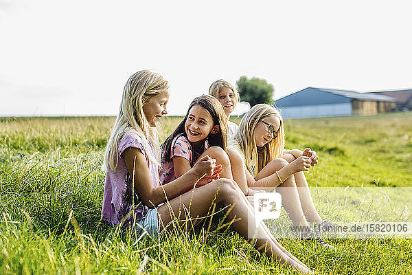 Girls sitting on a field in the countryside
