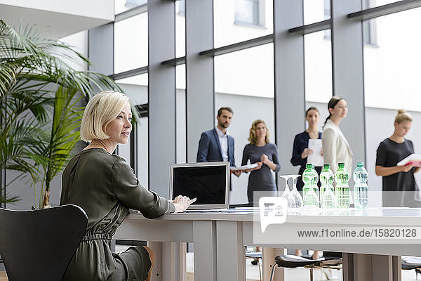 Businesswoman working in office buidings  while colleagues are queing for business meeting