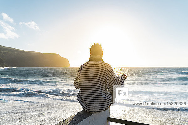 Mann meditiert bei Sonnenuntergang an der Küste Sao-Miguel-Insel Azoren Portugal