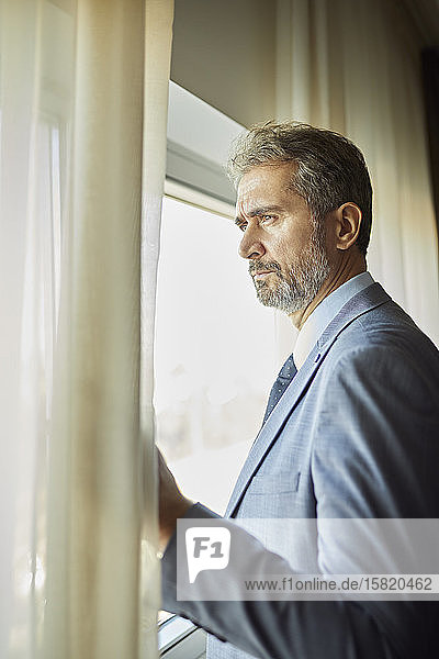 Portrait of businessman looking out of window