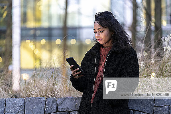 Junge Frau benutzt Handy in der Stadt