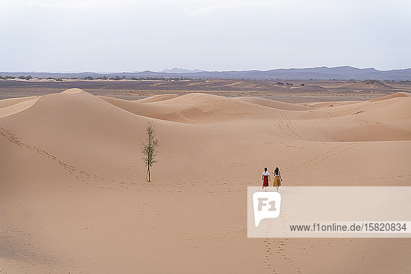 Two young women walking in Sahara Desert  Merzouga  Morocco