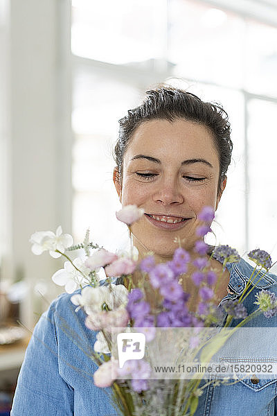 Bildnis einer lächelnden Frau mit Blumenstrauss