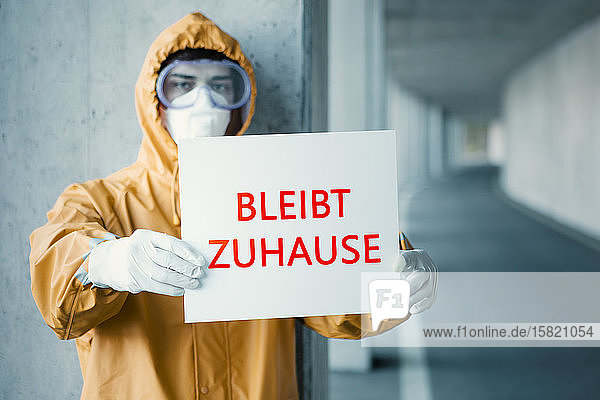Porträt eines Mannes in Schutzkleidung mit einem Schild