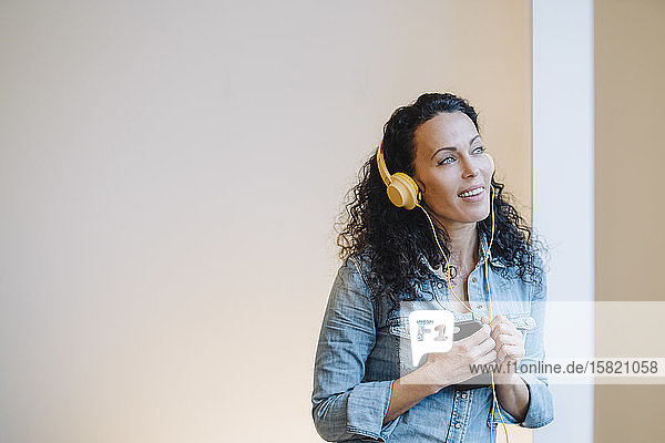 Frau  die Musik hört  Kopfhörer trägt  ein Smartphone benutzt