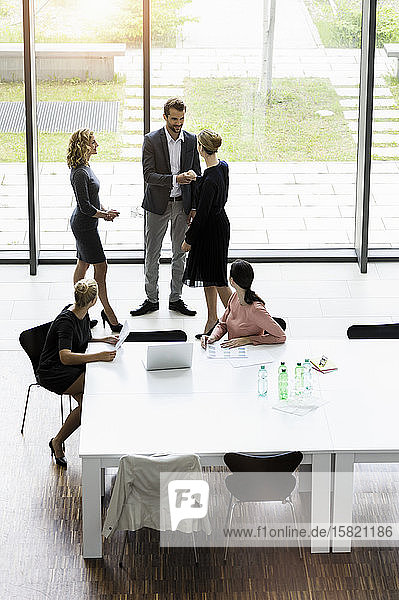 Geschäftsleute beim Händeschütteln im modernen Büro-Konferenzraum