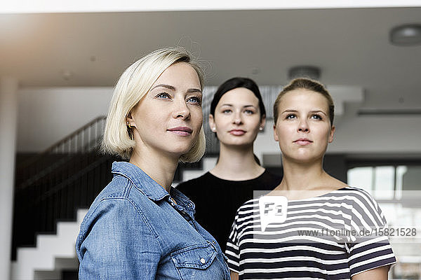 Portrait of confident young businesswomen in office looking away