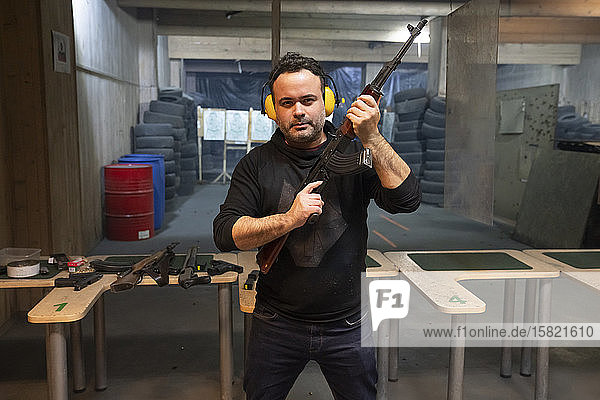 Portrait of a man with a gun in shooting range
