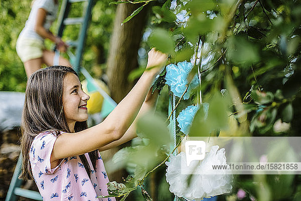 Mädchen schmückt den Garten für eine Geburtstagsfeier
