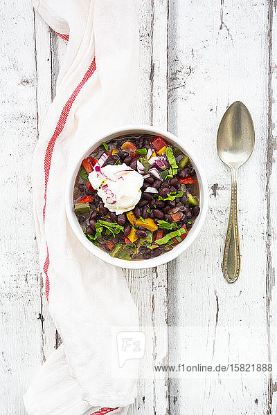 Schüssel schwarze Bohnensuppe mit Paprika Koriander Sauerrahm und roten Zwiebeln