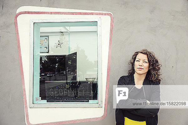 Porträt einer brünetten Frau neben einem Fenster eines Retro-Bistros
