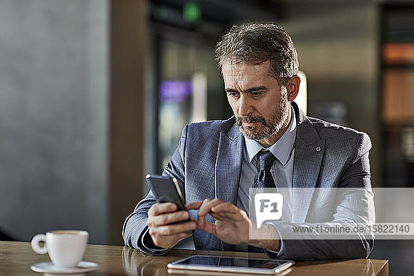 Businessman using smartphone at table
