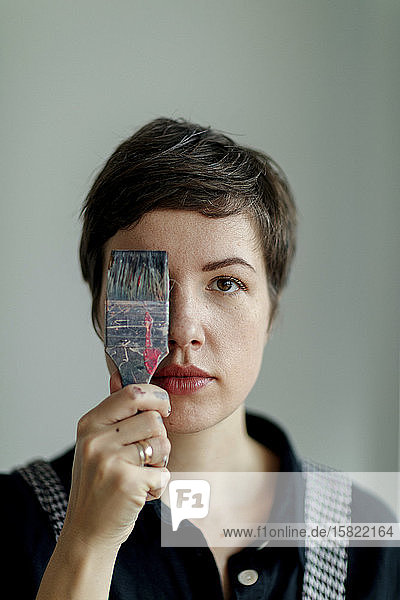 Portrait of a female painter holding a paintbrush