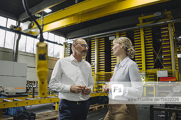 Mann und Frau im Gespräch in einer Fabrik