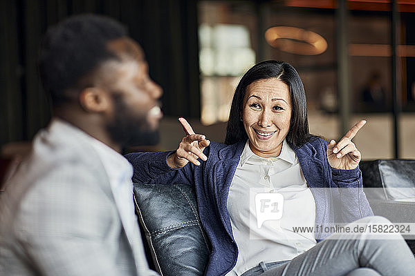 Businessman and businesswoman sitting on couch in hotel lobby