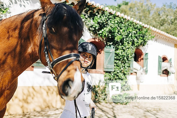 Teenager mit Down-Syndrom kümmert sich um Pferd und bereitet Pferd zum Reiten vor