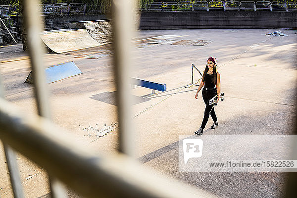 Young woman with skateboard at skatepark