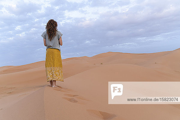 Junge Frau auf einer Sanddüne in der Wüste Sahara Merzouga Marokko