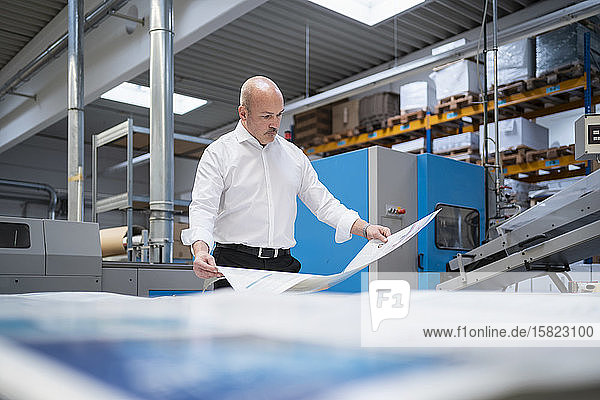 Businessman in a printing plant checking product