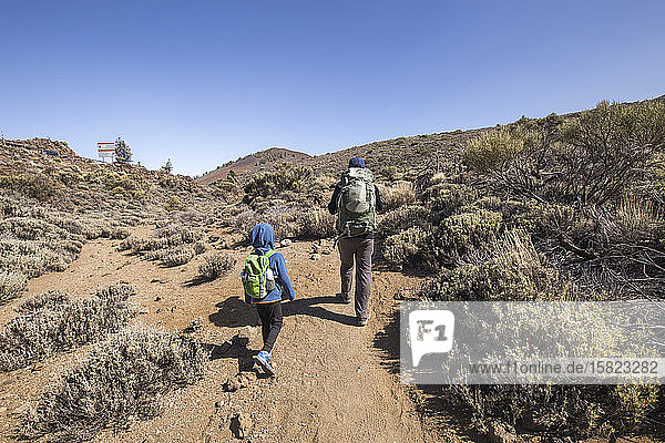 A father and his son trekking in the Arenas Negras area  Teide National Park  Tenerife  Spain