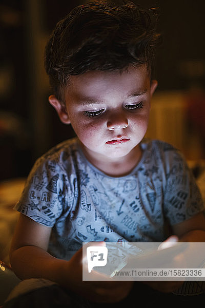 Porträt eines Kleinkindes beim Betrachten eines Smartphones
