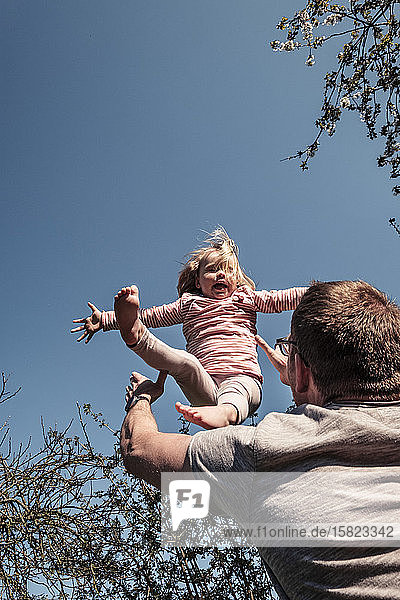 Vater wirft kleine Tochter in die Luft